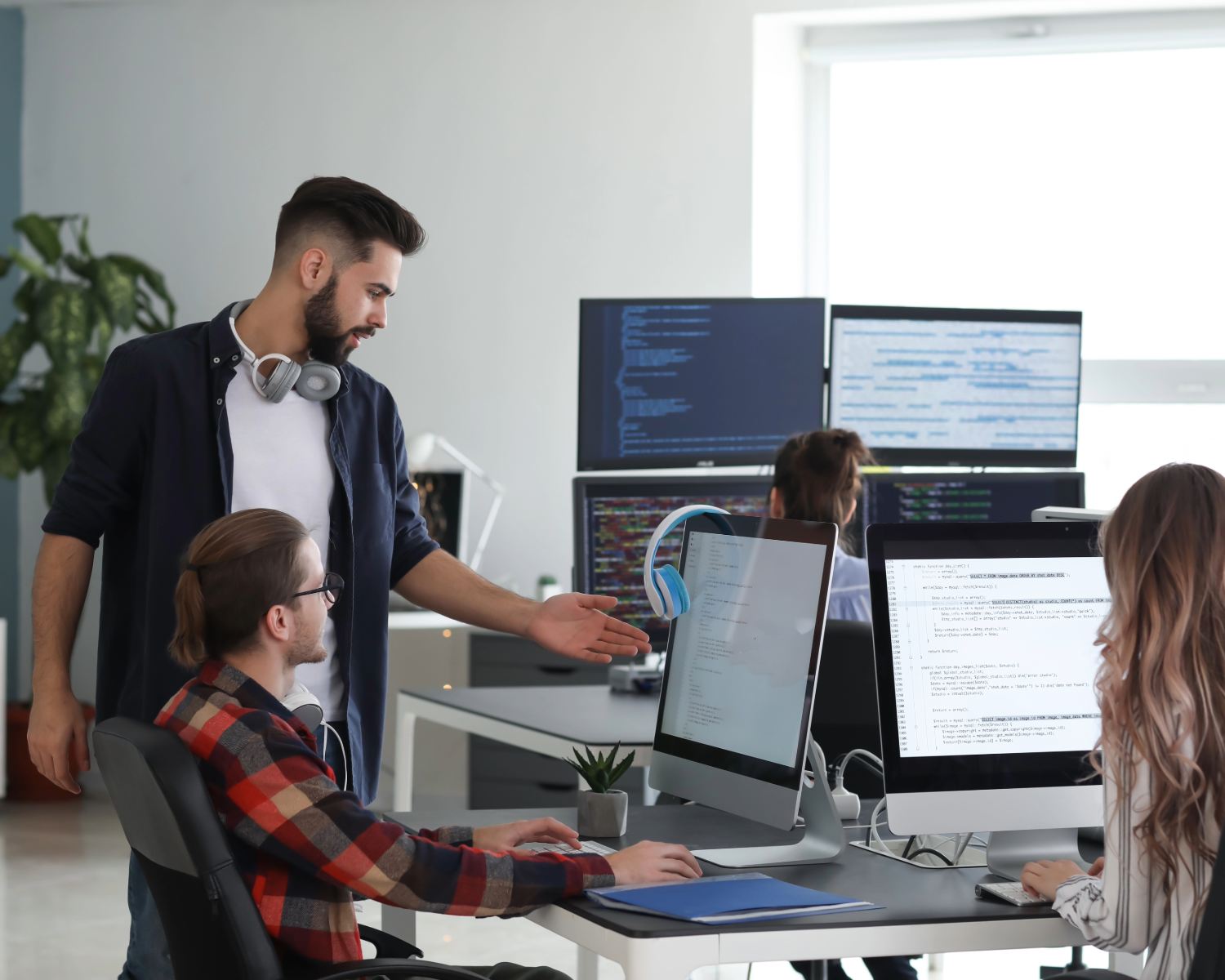 IT professionals collaborating on code in a modern tech workspace