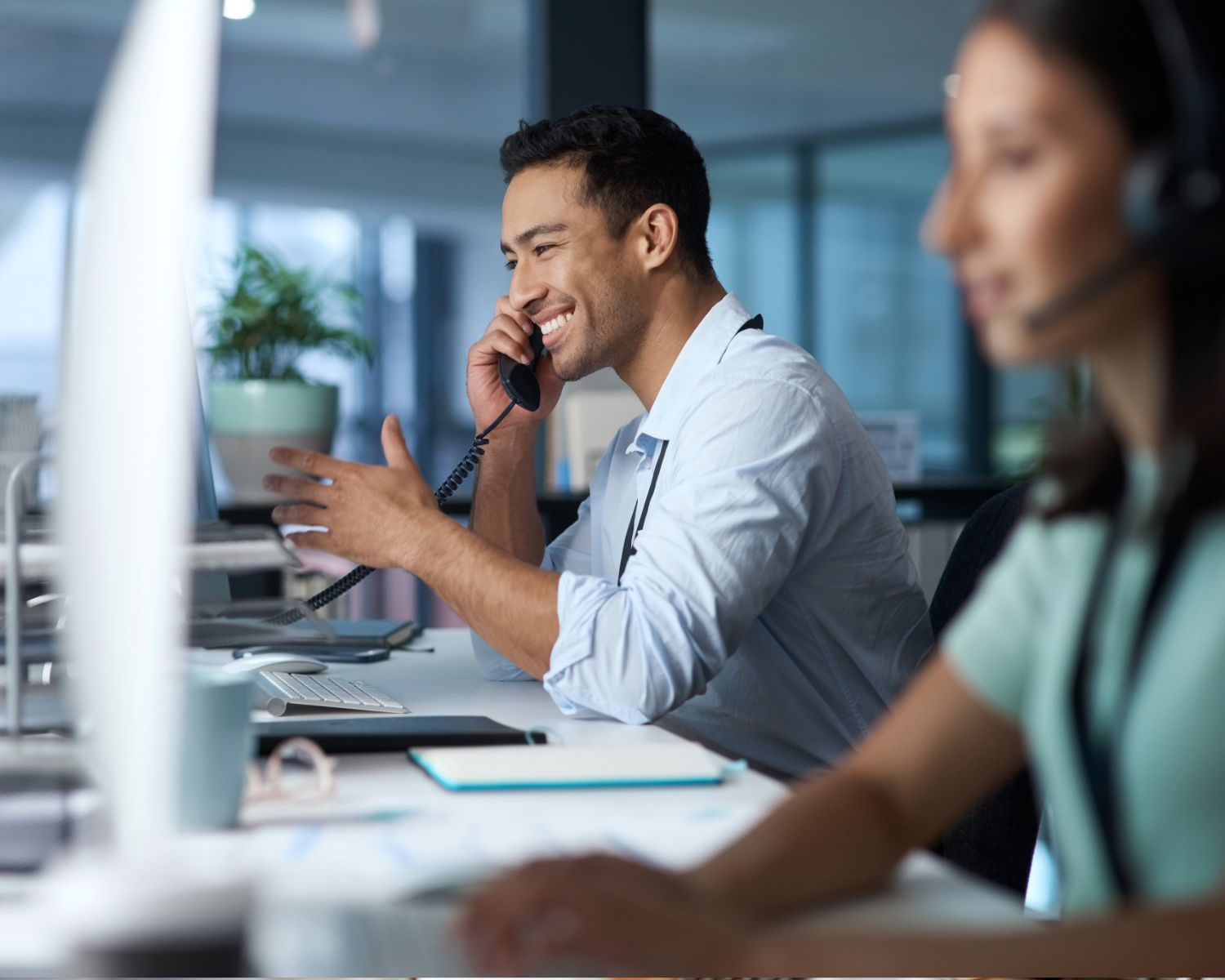 IT support specialist providing phone-based helpdesk assistance in a modern office
