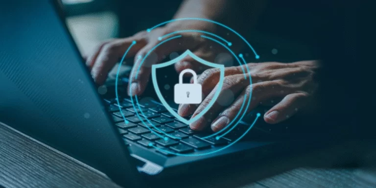 Hands typing on a laptop with a digital shield and padlock icon, representing cyber security awareness.